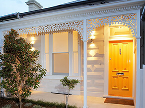 White Neutral Federation Front Exterior with Bold Yellow Door and Tiled Porch with Garden